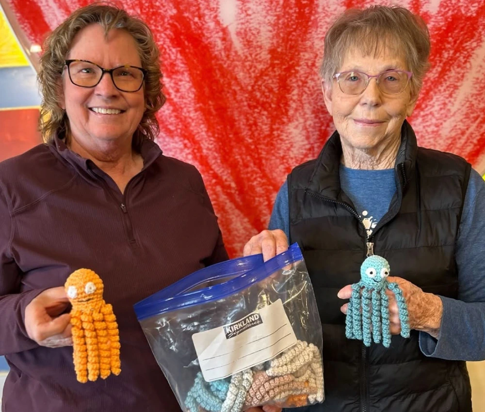 two volunteers with handcrafted octopi