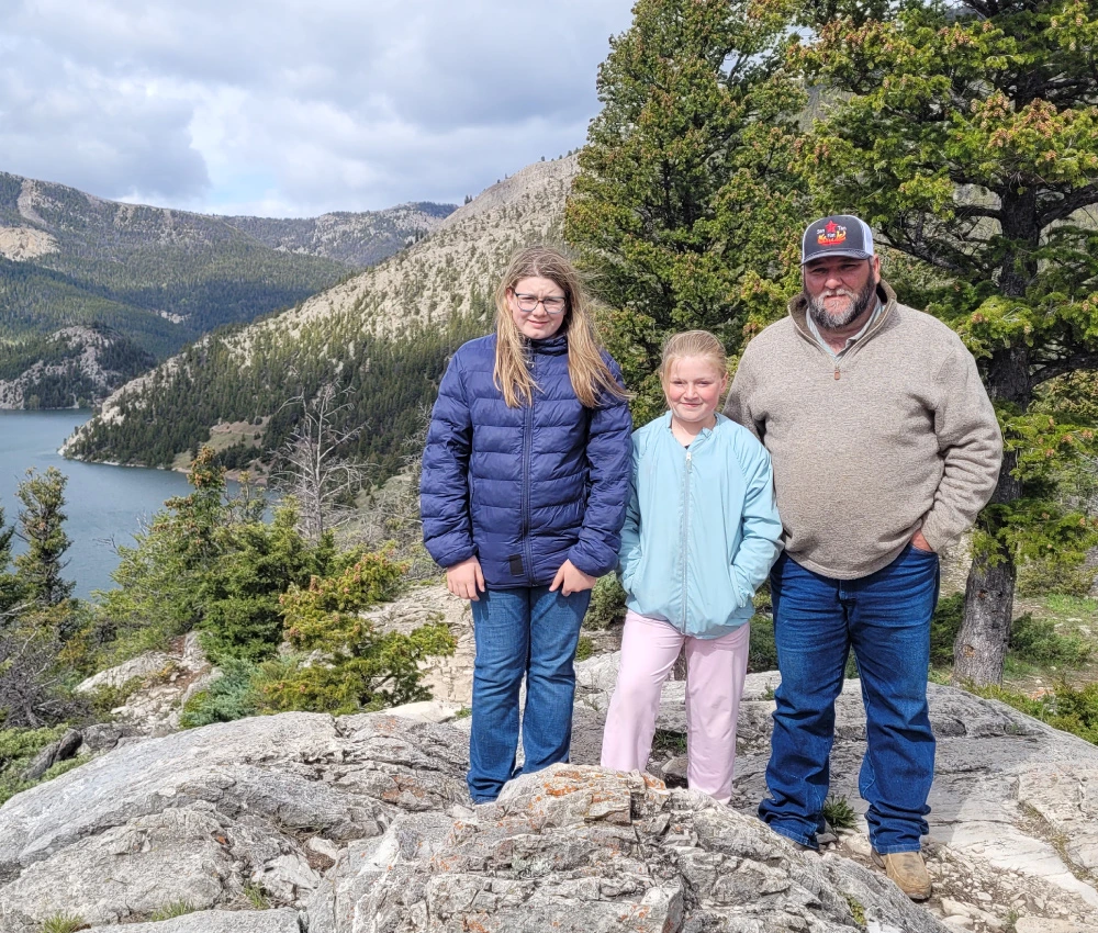 The Hall Family standing on picturesque rock formation overlooking a water area
