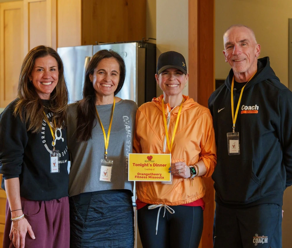donors standing with a sign describing their group's contributions to the meal