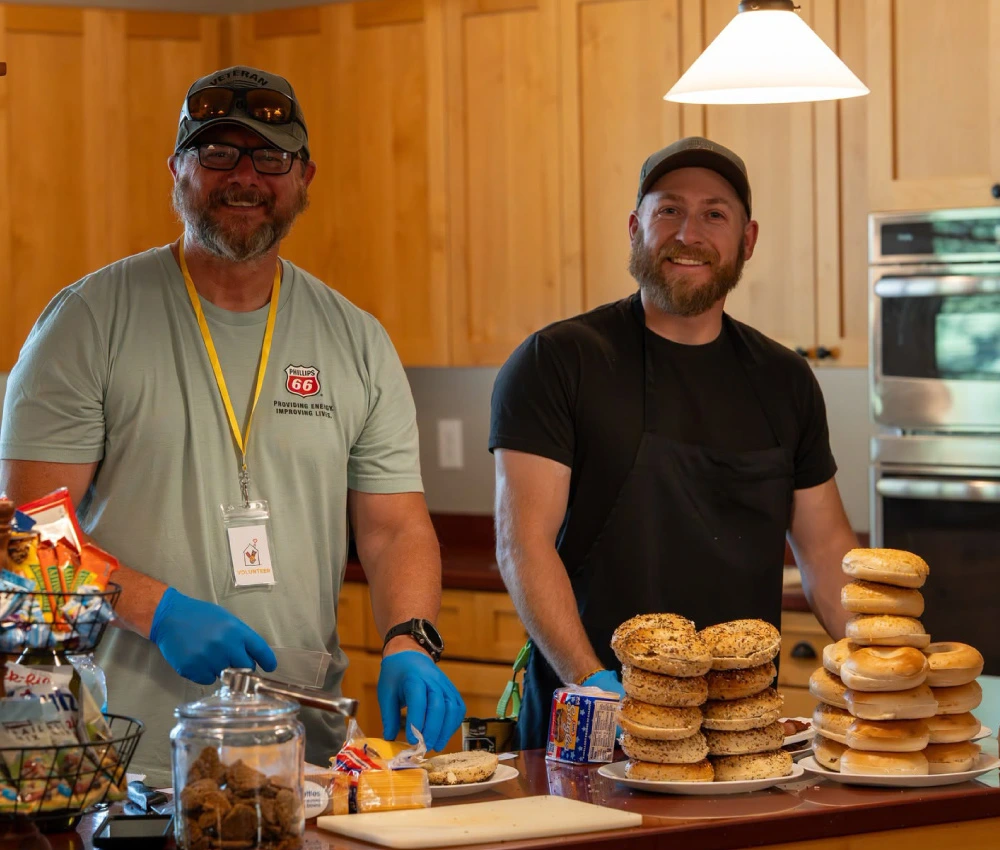 two volunteers working to prepare a warm breakfast for our families