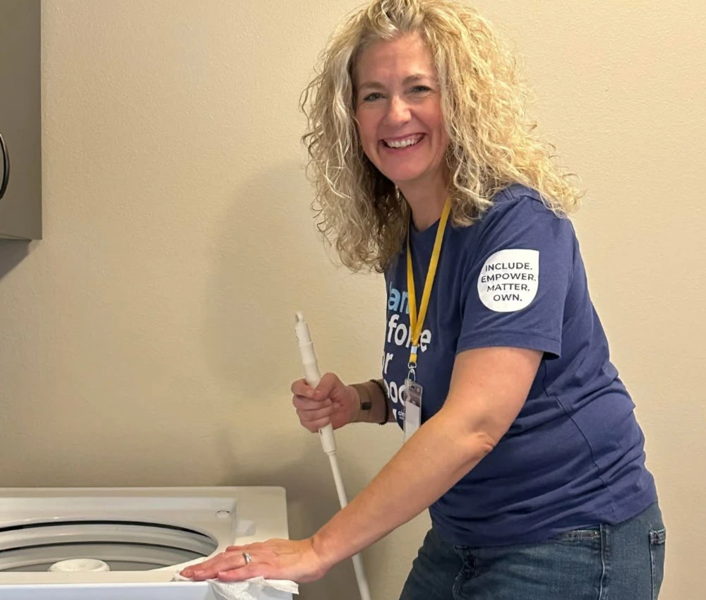 adult female smiling as she works to clean our laundry facilities